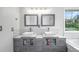 Bathroom boasts double sinks, modern fixtures, and an abundance of natural light from the large window at 5774 S Genoa Ct, Aurora, CO 80015