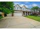 Beautiful home with a three-car garage, a well-kept lawn, and a welcoming front porch at 5774 S Genoa Ct, Aurora, CO 80015