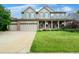 Charming two-story home with a well-manicured front lawn, three car garage, and inviting porch at 5774 S Genoa Ct, Aurora, CO 80015