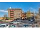 Brick apartment building featuring balconies and ample parking spaces on a clear, sunny day at 3047 W 47Th Ave # 105, Denver, CO 80211