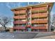 Brick apartment building with multiple levels of balconies and parking at 3047 W 47Th Ave # 105, Denver, CO 80211