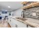 Updated kitchen features granite countertops, modern backsplash, and stainless steel sink at 3047 W 47Th Ave # 105, Denver, CO 80211