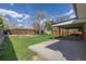 Large backyard featuring a covered patio, green grass, garden area, mature trees, and a storage shed at 6611 Lamar St, Arvada, CO 80003