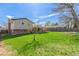 Large lawn with trees, a playset, and patio attached to the house in the background at 6611 Lamar St, Arvada, CO 80003