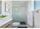 Updated bathroom with tiled shower, frosted sliding door, and modern vanity at 6611 Lamar St, Arvada, CO 80003