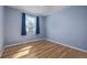 A well-lit bedroom with hardwood floors, a large window, and neutral-colored walls at 6611 Lamar St, Arvada, CO 80003