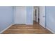 Bedroom featuring hardwood floors, a closet, and a doorway to another room at 6611 Lamar St, Arvada, CO 80003
