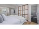 Bright bedroom features a queen bed and adjoining bathroom with subway tile at 6611 Lamar St, Arvada, CO 80003