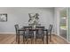 Staged dining room with hardwood floors, seating for six, and view of yard at 6611 Lamar St, Arvada, CO 80003