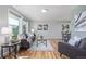 Bright living room featuring hardwood floors, large windows, modern decor, and comfortable seating arrangements for relaxation and entertainment at 6611 Lamar St, Arvada, CO 80003
