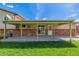 Covered patio with brick accents and wooden support beams, accessible from the home's interior at 6611 Lamar St, Arvada, CO 80003