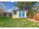 Colorful storage shed with blue trim and a window, nestled in the corner of the backyard at 6611 Lamar St, Arvada, CO 80003