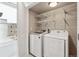 Bright laundry room features a modern washer and dryer with shelving for organized storage at 2150 Eliot St, Denver, CO 80211