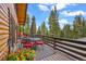 Inviting deck with outdoor seating, umbrella and colorful flowers, ideal for enjoying scenic views and alfresco dining at 1673 Sinton Rd, Evergreen, CO 80439