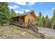 Charming log home with a spacious deck, perfect for outdoor living and surrounded by lush greenery and serene nature at 1673 Sinton Rd, Evergreen, CO 80439