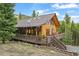 Exterior view of log home featuring a large deck and mountain views at 1673 Sinton Rd, Evergreen, CO 80439