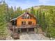Inviting cabin with large windows, wood siding, elevated deck and two-car garage at 1673 Sinton Rd, Evergreen, CO 80439