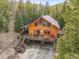 Stunning log home with expansive deck, nestled amongst the trees, and featuring an attached garage for convenience at 1673 Sinton Rd, Evergreen, CO 80439