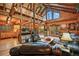Cozy living room featuring wood beams, a stone fireplace, and natural light, creating a warm and inviting atmosphere at 1673 Sinton Rd, Evergreen, CO 80439