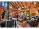 Stylish living space with a fireplace, comfortable leather seating, and large windows offering scenic outdoor views at 1673 Sinton Rd, Evergreen, CO 80439