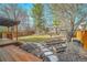 Large backyard featuring a wood deck, stone pathways, garden beds, and a fenced yard at 1696 Waneka Lake Trl, Lafayette, CO 80026