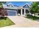 Charming blue two-story home with landscaped yard, solar panels, and covered porch with seating at 1038 Mircos St, Erie, CO 80516