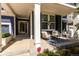 Inviting front porch with seating, a vibrant rug, flowers, and views of the main entry at 1038 Mircos St, Erie, CO 80516