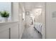 Well-lit hallway leading to a bedroom, featuring clean white walls, accent wall and carpeted flooring at 1038 Mircos St, Erie, CO 80516