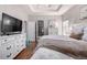 Bedroom featuring hardwood floors, tray ceiling and ensuite access at 1038 Mircos St, Erie, CO 80516
