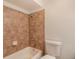Cozy bathroom features a tub with tiled shower surround and a white toilet at 1145 Rosemary St # 105, Denver, CO 80220