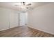 A bedroom with neutral walls, wood-look flooring, closet, and a ceiling fan at 1145 Rosemary St # 105, Denver, CO 80220