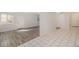 View of the bright basement featuring neutral walls and new laminate floors leading to the tiled kitchen at 1145 Rosemary St # 105, Denver, CO 80220