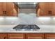 Close up of cooktop with stainless steel vent and backsplash in bright, modern kitchen at 788 Alumroot St, Castle Rock, CO 80104