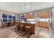 Open kitchen with wood cabinets, island seating, stainless appliances, and dining area at 788 Alumroot St, Castle Rock, CO 80104