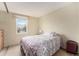 Bright bedroom with floral bedding, large window, and suitcase at 19707 E Princeton Pl, Aurora, CO 80013