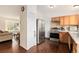 Open kitchen view with stainless steel appliances, wood cabinets, and hardwood floors at 19707 E Princeton Pl, Aurora, CO 80013