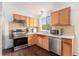 Well-lit kitchen with stainless steel appliances, wood cabinets, and large window above the sink at 19707 E Princeton Pl, Aurora, CO 80013