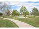 Scenic park view featuring lush green grass, mature trees, and a winding sidewalk at 19707 E Princeton Pl, Aurora, CO 80013