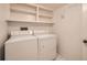 Laundry room with shelving above a full size washer and dryer at 1551 Larimer St # 1402, Denver, CO 80202