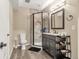 Beautiful bathroom with a tiled walk-in shower, dark vanity, and gray wood-look flooring at 2043 S Cathay Way, Aurora, CO 80013