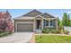 Charming single-story home with a two-car garage, a covered porch, and a well-manicured lawn at 2043 S Cathay Way, Aurora, CO 80013