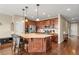 Gourmet kitchen with wood cabinetry, granite island, stainless appliances, and modern lighting at 2043 S Cathay Way, Aurora, CO 80013