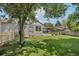 Lush green backyard with shade tree, rope swing, and outdoor dining area at 9630 W 38Th Ave, Wheat Ridge, CO 80033