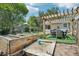 Landscaped backyard featuring a pergola, raised garden beds, and a sandbox area, perfect for relaxation and outdoor activities at 9630 W 38Th Ave, Wheat Ridge, CO 80033
