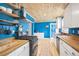 Stylish kitchen featuring blue walls, wood countertops, open shelving, and modern appliances, perfect for culinary enthusiasts at 9630 W 38Th Ave, Wheat Ridge, CO 80033