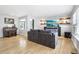 View of open living room with hardwood floors, a modern sofa, and a wall-mounted TV with shelves at 9630 W 38Th Ave, Wheat Ridge, CO 80033
