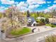 Aerial view of a charming two-story home with a lush lawn, mature trees, and a single-car garage at 12212 W 60Th Pl, Arvada, CO 80004