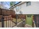 View of the home's walkout basement with a secure entrance, brick accents, and metal railings at 12212 W 60Th Pl, Arvada, CO 80004