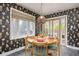 Charming dining area featuring a round table, stylish wallpaper, and abundant natural light at 12212 W 60Th Pl, Arvada, CO 80004
