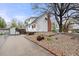 Home exterior with beautiful landscaping, rock garden and mature trees at 12212 W 60Th Pl, Arvada, CO 80004